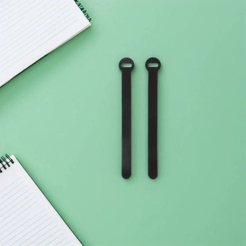 Super Solid 100 Piece Pack Of Self Adhesive Nylon Cable Ties With Cute Round Heads on a mint green surface next to a notepad.