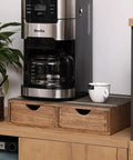 Dark wood Coffee Pods Storage Drawer Organizer with two drawers under coffee maker on a countertop.