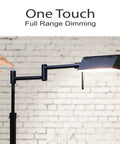 Dimmable LED Pharmacy Floor Lamp With Full Range Dimming And 360 Degree Swing Arms, Adjustable Height Standing Lamp For Reading Sewing And Crafty Projects, ETL Listed Black showcasing its one-touch dimming feature against a white brick wall.