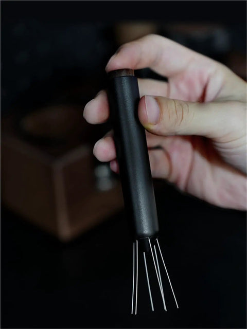 No Fuss WDT Needle Tool For Espresso Brewing Retractable Telescopic Coffee Ground Distributor held in hand for easy use.