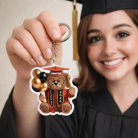 Graduate holding Personalized Graduation Bear Keychain For The Grad Custom Name And Class Year Keepsake Cute Senior Design Gift For Class Of 2026 Unique Gift Idea For The Graduate And Their Big Milestone