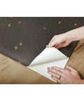 Hands peeling Upon A Star Black And Metallic Peel And Stick Wallpaper Easy Install On Smooth Walls Removable No Residue