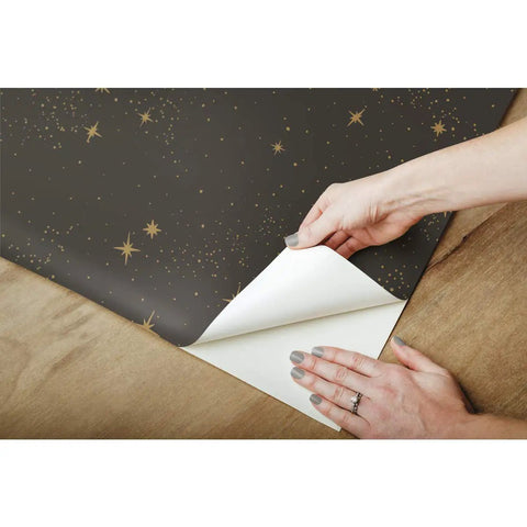 Hands peeling Upon A Star Black And Metallic Peel And Stick Wallpaper Easy Install On Smooth Walls Removable No Residue