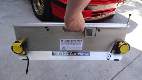 Heavy Duty 2 Wheel Alignment Tool For Camber Caster And Toe With Knockout Precision Wheel Standoffs held by a person.