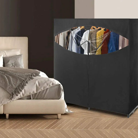 Black Grab-And-Go Portable Wardrobe Closet Organizer With Hanging Rack next to a bed in a bedroom, 60L x 19.5W x 64H
