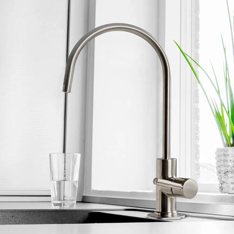 Premium Heavy Duty Reverse Osmosis Faucet For Kitchen Sink with brushed nickel finish, flexibly shaped spout, and glass of water.
