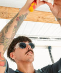 Man wearing Kickass Polarized Safety Glasses Featuring Rounded Retro Frames and Anti Scratch Coatings while working on a project.