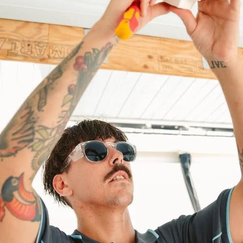 Man wearing Kickass Polarized Safety Glasses Featuring Rounded Retro Frames and Anti Scratch Coatings while working on a project.