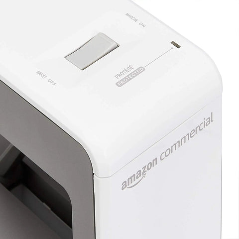 White Amazon Commercial power hub featuring switch and label on top corner. Visible elements include branding and control labels. Must-Have AC And USB Desktop Power Hub With Surge Protection, 3 Outlets And 4 USB Ports, 6-Foot Heavy-Duty Cord, 90 Degree Swivel, 15A 120V 1800W, Fast USB Charging Up To 2.4A Per Port, Total 3.4A.