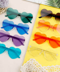Heart Shaped Neon Green Sunglasses For Women And Men Unisex Rimless Glasses Lightweight 2-pack shown in different colors on yellow mat