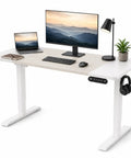 Zero Stress Oak Electric Standing Desk Featuring Four Memory Buttons Plus Child Lock Safety For Seamless One Button Height Adjustment In Your Everyday Home Office Setup with a modern setup including a monitor and laptop.