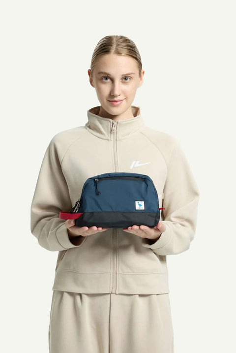 Person holding a teal 5L travel toiletry bag with waterproof wet dry compartment and padded bottom, ideal for weekend getaways.