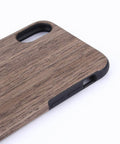 Close-up of wooden phone case with natural grain finish and precise cutouts for camera and buttons on a white background.