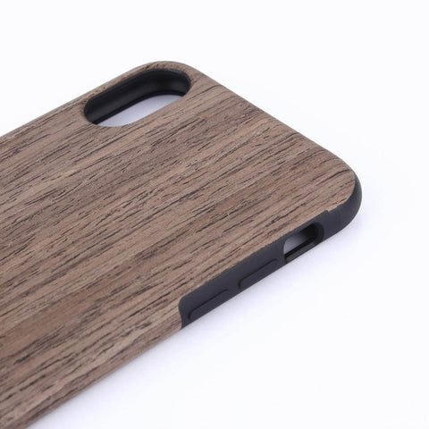 Close-up of wooden phone case with natural grain finish and precise cutouts for camera and buttons on a white background.
