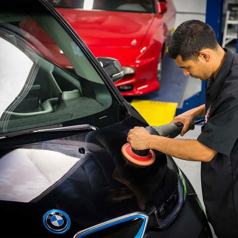 Person using Hex-Logic Quantum Buffing Pad Sampler Kit Four Pad Set for Pro Polishing on car hood in garage.