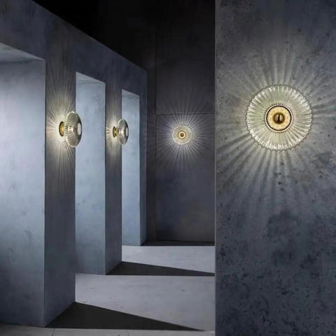 Awsinil Fluted Glass Wall Sconce, Modern Iron Round Decorative Wall Light illuminating a minimalist interior with shadows.