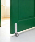 Premium 6 Pack Silver Sliding Door Roller Casters With Reinforced Steel Core And TPE Wheels Includes Anti Sagging Floor Guide For Barn Doors That Glide Damn Smooth Every Time close-up of roller caster attached to green barn door.