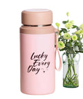 800ml Insulated Water Bottle With Tea Infuser, Leakproof Vacuum-Sealed Double-Wall Stainless Steel Flask next to green floral arrangement