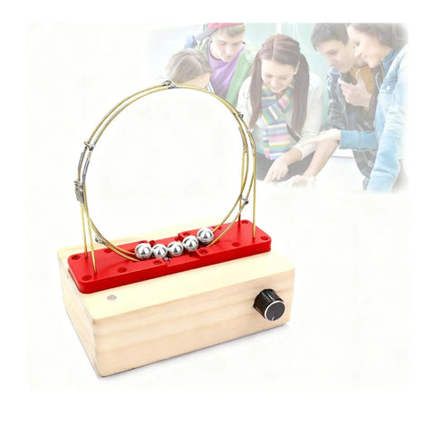 Hands On Perpetual Motion Science Kit With Electromagnetic Cyclotron And Iron Ball Circular Motion Demonstrator Magnetic Drive Tech For STEM Education Red Color Edition on wooden base, students observing in background.