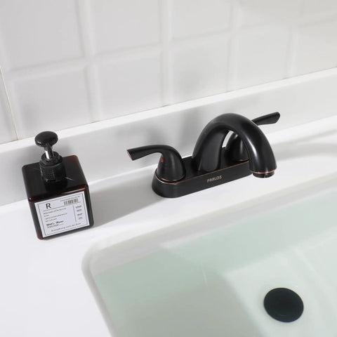 Two-Handle Bathroom Sink Faucet With Oil Rubbed Bronze Finish, Lead-Free Deck Mounted, next to soap dispenser, in white sink