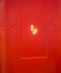 Close-up of Half Size Self Healing Silhouette Reactive Shooting Target with hit marks on red polymer surface.