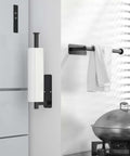 No Drill Under Cabinet Paper Towel Holder With Self Adhesive Wall Mount for Kitchen Rack in matte black finish near kitchen counter.