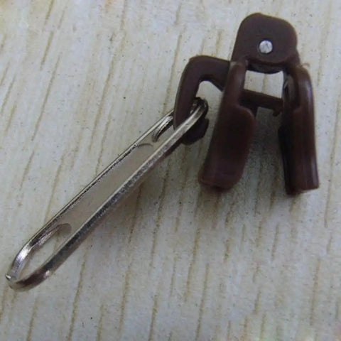 Close-up of a brown zipper slider from Six Piece Black Universal Instant Zipper Repair Kit With Replacement Teeth Zippers And Sliders For Quick Fixes On Coats Bags And Luggage No Brand Needed Great For D I Y Repairs On The Go