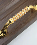 Level Up Your Cabinet Game With These Crisp 96Mm Drawer Pulls Decked Out In Glossy 24K Gold And Heavyweight K9 Crystal That Truly Bring The Hollywood Glamour Everyday - 96mm gold drawer pull with crystals on wood.