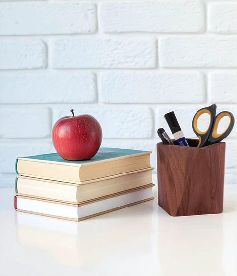Black Walnut Wood Pen Holder For Desk on white surface with books and apple