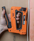 Hand using stapler to install Heavy Duty Insulated Staples For Romex And NM Cables 19 32 By 11 32 Inch Boss Grade Secure