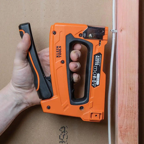 Hand using stapler to install Heavy Duty Insulated Staples For Romex And NM Cables 19 32 By 11 32 Inch Boss Grade Secure