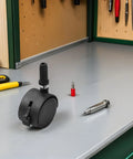 4pcs Inch Swivel Caster Wheels for Furniture and Displays Black placed on a workbench, showcasing sturdy design and brake function.