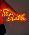 Person holding Til Death Neon Light Sign USB Powered LED Decor For Halloween Weddings Parties And Bridal Showers 17 Inch Orange Bedroom Wall Decor With On Off Switch 5V Dope Vibe