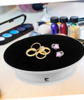 Rotating Electric Turntable Display Stand With Smooth Motorized Motion showcasing rings and earrings on a black velvet surface.
