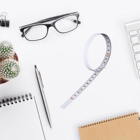 Six Pack Adhesive Flexible Tape Measures Set, 1m And 2m Lengths, shown with glasses and stationery on a desk