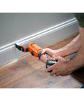 Person using 18V Cordless Oscillating Multi Tool Kit With Two 2.0Ah Batteries And Charger Quick Change System on baseboard.