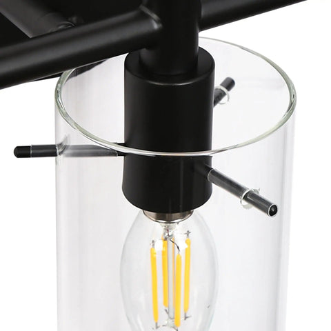 Close-up of black metal fixture with clear glass shade, showing bulb and details for 3-Light Gold Vanity Light With Seeded Glass Shades For Bathroom Over Mirror, Sleek Fixture With Cozy Glow And Luxe Seeded Glass Finish, 24.5 Inch Long Bath Vanity Lighting.