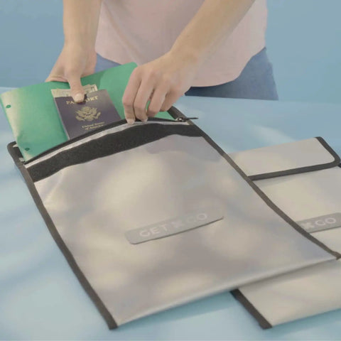 Person placing passport and documents in Fireproof Bug Out Backpack For Docs And Tech, 20L Water-Resistant Go Bag That Withstands 1832 Fahrenheit