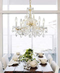 Modern Crystal Chandelier Light Fixture With Six Lights, Raindrop Pendant Crystals In Maria Theresa Brass Finish over dining table