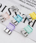 20 Pairs Quick Fix Hem Clips and Reusable Clamps for Pants, transparent purple tops with sturdy metal base laid out on paper