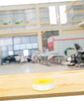 High Temp PTFE Sealing Tape Thread Sealant For Water Leaks displayed on a wooden table with a blurred industrial background