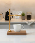 Heavy Copper Alloy Pour Over Coffee Dripper Stand For Kitchen Counter Hella Steady Cone Filter Holder on wooden base with glass filter.
