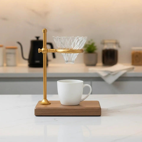 Heavy Copper Alloy Pour Over Coffee Dripper Stand For Kitchen Counter Hella Steady Cone Filter Holder on wooden base with glass filter.