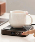 Never Suffer Through Lukewarm Coffee Again With This 20W Adjustable Mug Warmer on desk, showing a ceramic cup and control settings.