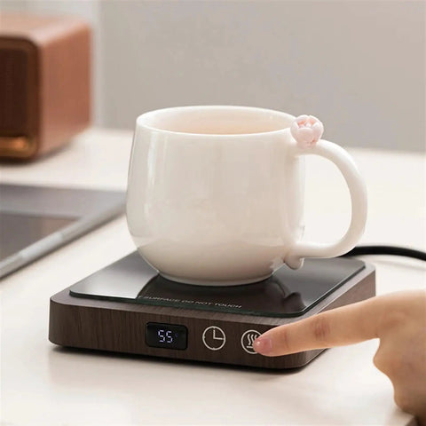 Never Suffer Through Lukewarm Coffee Again With This 20W Adjustable Mug Warmer on desk, showing a ceramic cup and control settings.