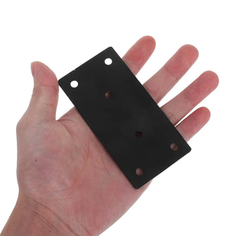 Hand holding a beefy heavy duty flat plate corner bracket with screws black 10x5cm set for tables and chairs no wobble deformation resistant.