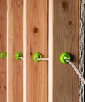 EZ Guard single-stud electrical wire protector green grommets installed in wooden studs with white wire (5-pack)