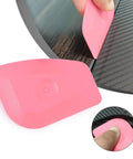 Pro Vinyl Wraps Applicator Tool Kit: pink plastic squeegees used for car wrap with carbon-fiber film background