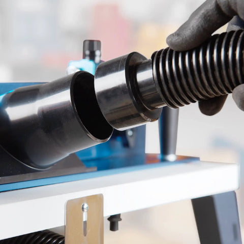Close-up of heavy-duty dust collection kit attachment on Rock Solid Benchtop Router Table Setup with adjustable aluminum fence.