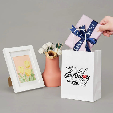 Gift scene with birthday Kraft paper bag and wrapped present, pink vase, floral art. Dope Custom Printed Kraft Paper Bags With Logo.
